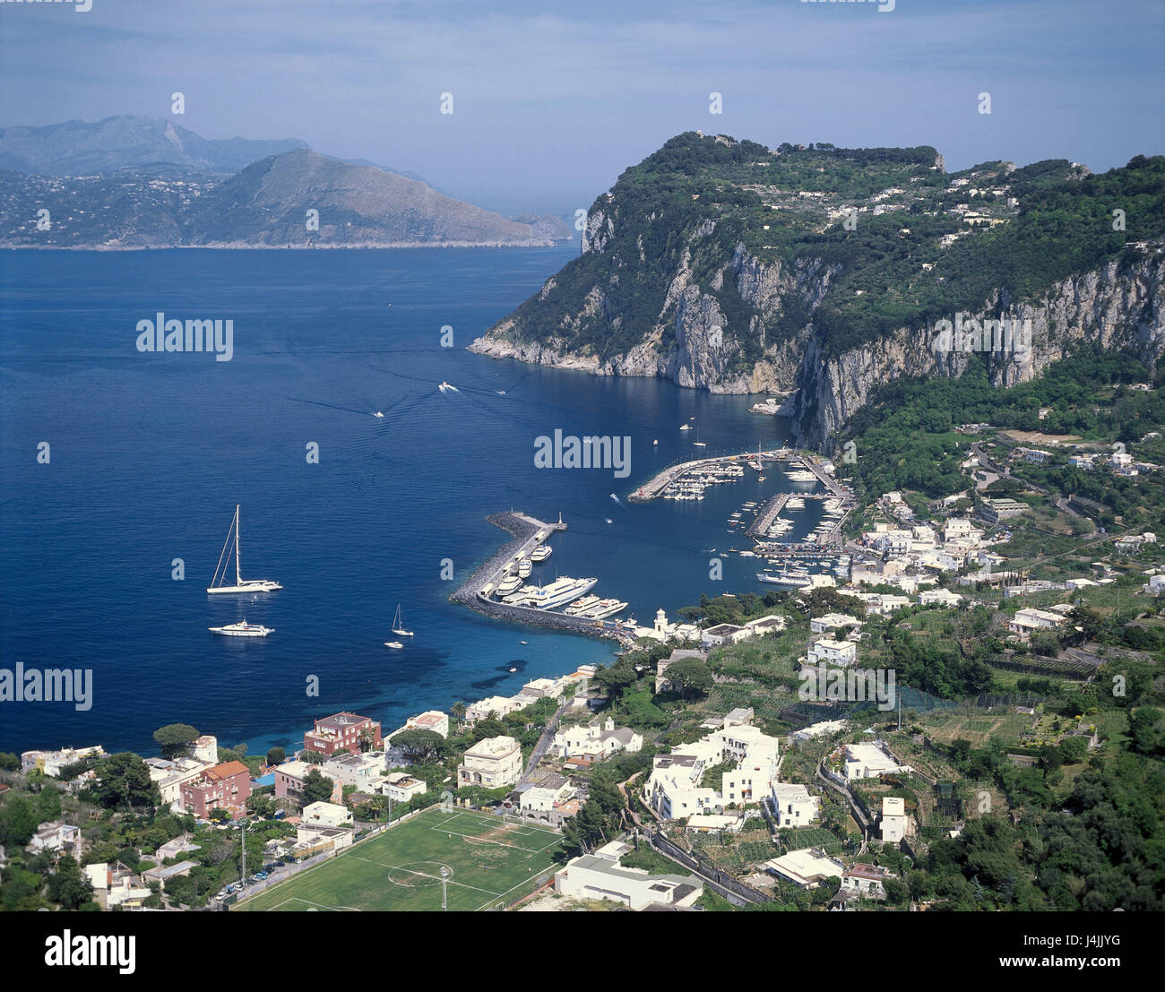 L'Italie, l'île de Capri, Kampanien, Marina Grand, port d'aperçu, le Mont Tiberio Europa, province de Naples, Capri, Isola Tu côte nord, la baie de Naples, la mer, la mer Méditerranée, Côte, côte de la bile, rock, côte escarpée, maisons, maisons résidentielles, Port, bassin du port, bateaux, navires, vue mainland Banque D'Images