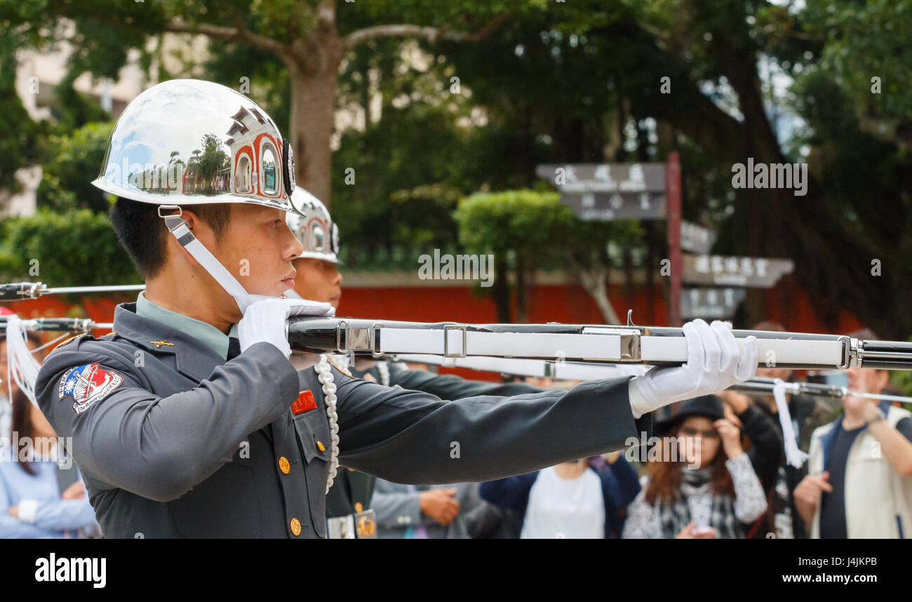 TAIPEI, Taïwan : Garde de cérémonie avec fusil et baïonnette à touriste à l'arrière-plan au Sanctuaire des martyrs de la révolution nationale Banque D'Images
