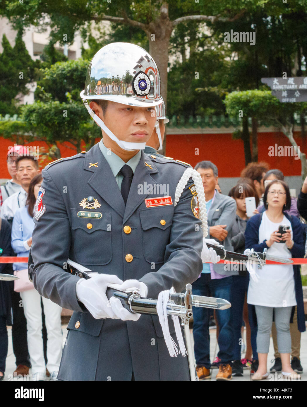 TAIPEI, TAIWAN : la modification de la Garde de cérémonie avec fusil et baïonnette à touriste à l'arrière-plan au Sanctuaire des martyrs de la révolution nationale Banque D'Images