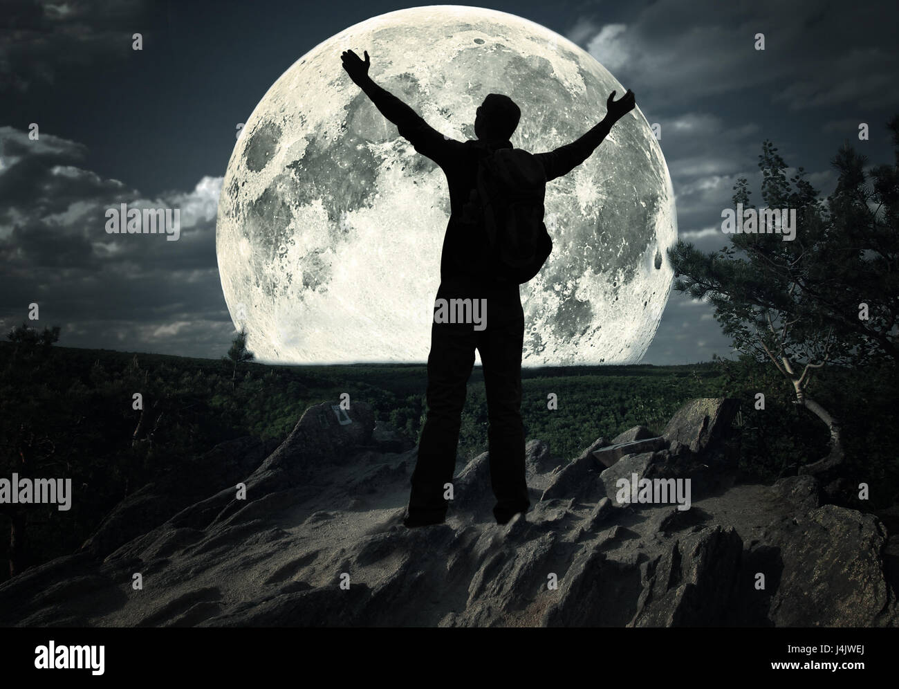 Homme debout sur le sommet de la montagne regarder la lune Banque D'Images