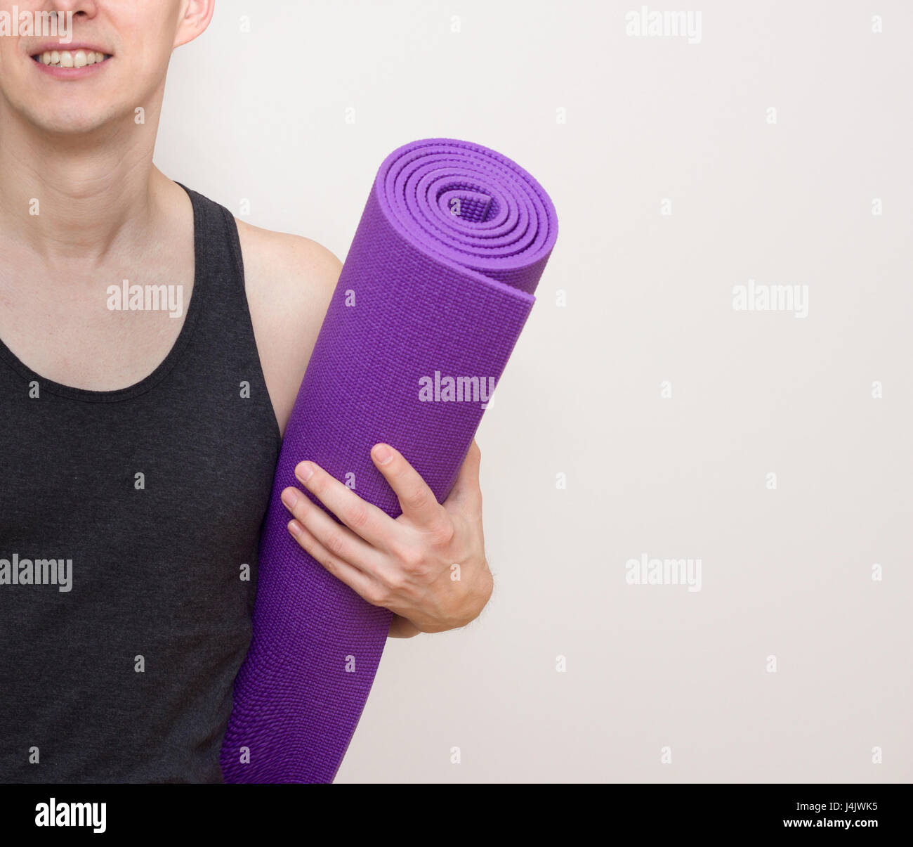 Young smiling man with yogi yoga mat Banque D'Images