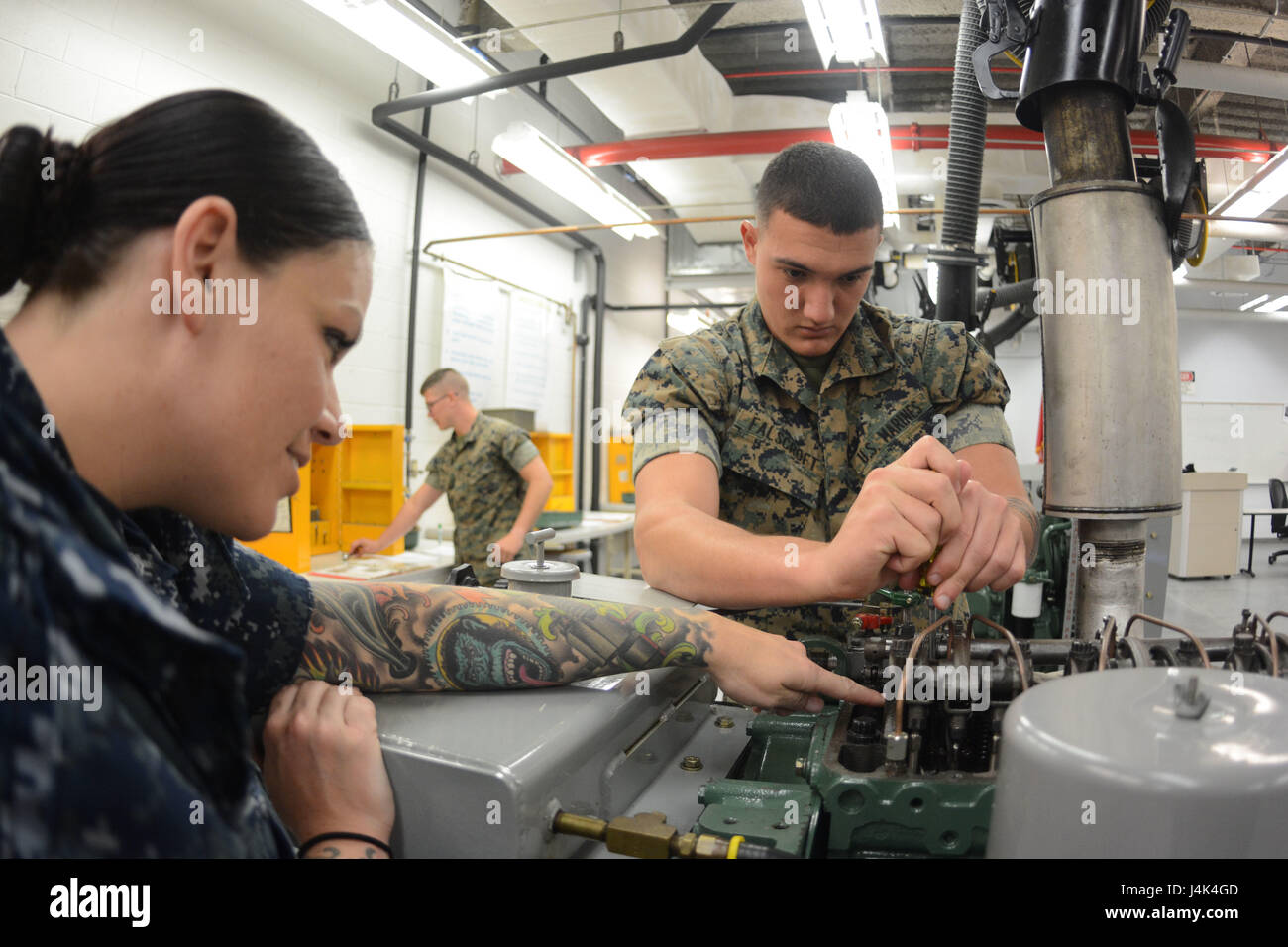 PENSACOLA, Floride-- Naval Air Technical Training Center (NATTC) Équipement de soutien à l'aviation de l'instructeur de l'École 'A' l'appui de l'Aviation 2ème classe technicien d'équipement (AW/SW) Lindsay-Kerr Vanessa montre Merritt Island, en Floride, les corps des marines américains de 1ère classe Falscroft privé Tyler points de réglage sur un moteur Detroit Diesel de la série 3-53 aide au cours de la formation Two-Stroke Moteur Diesel des TP 15 Mars à bord de la base aéronavale de Pensacola, en Floride. NATTC fournit la formation de l'entretien, l'appui de l'aviation navale, de l'entreprise environ 15 000 diplômés et marine, Marine Corps et intern Banque D'Images