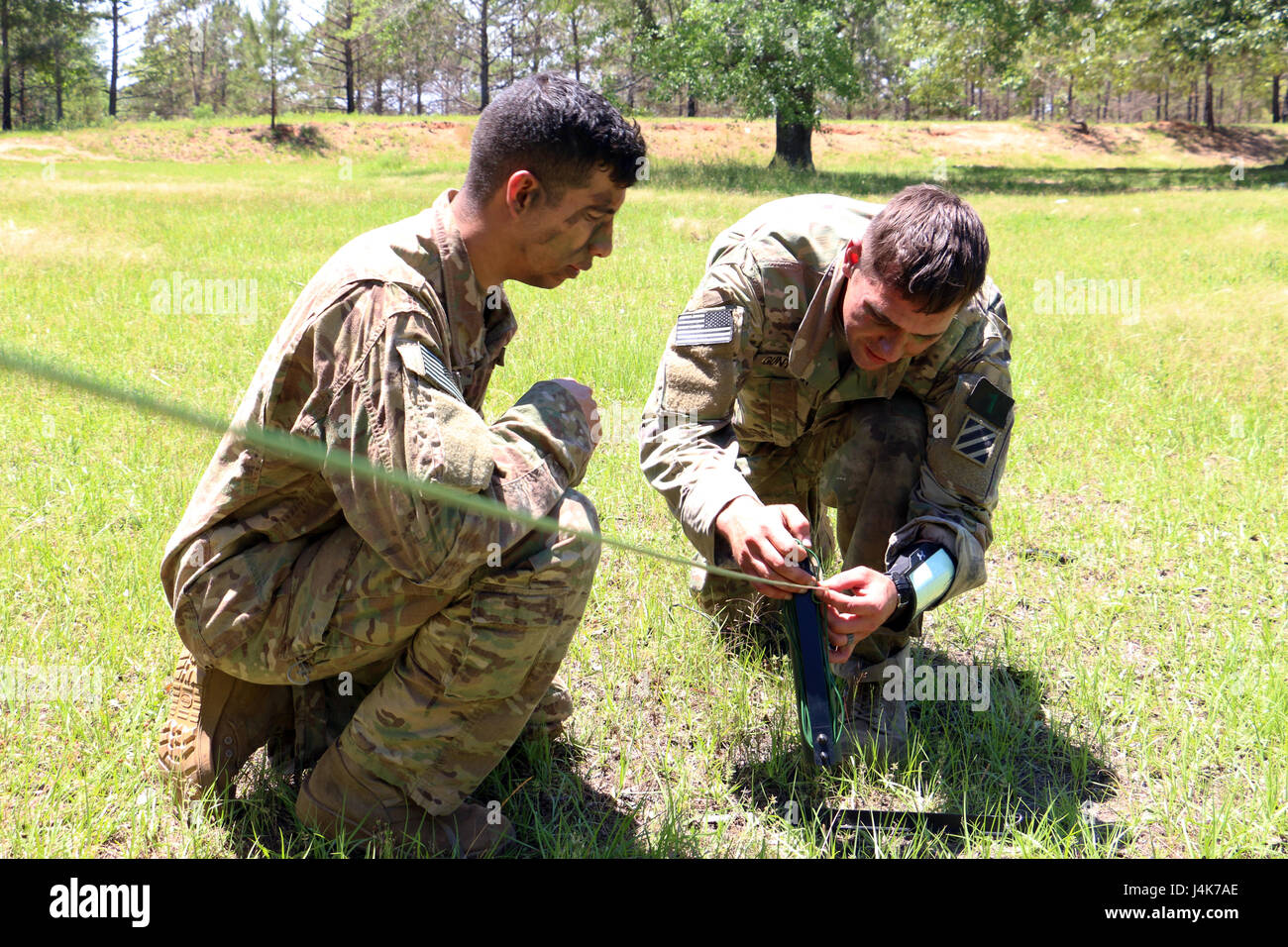 Le Sgt. Evan Gunther (à droite), chef d'équipe à la 3ème Division d'infanterie squad pour la Coupe du Gainey, les lieux d'un câble Harris 150 radio définie au cours d'une voie de communication, le 3 mai 2017 à Fort Benning, Géorgie La 3e brigade s'est classée deuxième à l'ID de la compétition de la Coupe 2017 Gainey, qui met en valeur la compétence, l'endurance physique et mentale, et l'esprit de compétition des soldats en reconnaissance de cavalerie recon et formations. (U.S. Photo de l'armée par le sergent. Candace Mundt/libérés) Banque D'Images