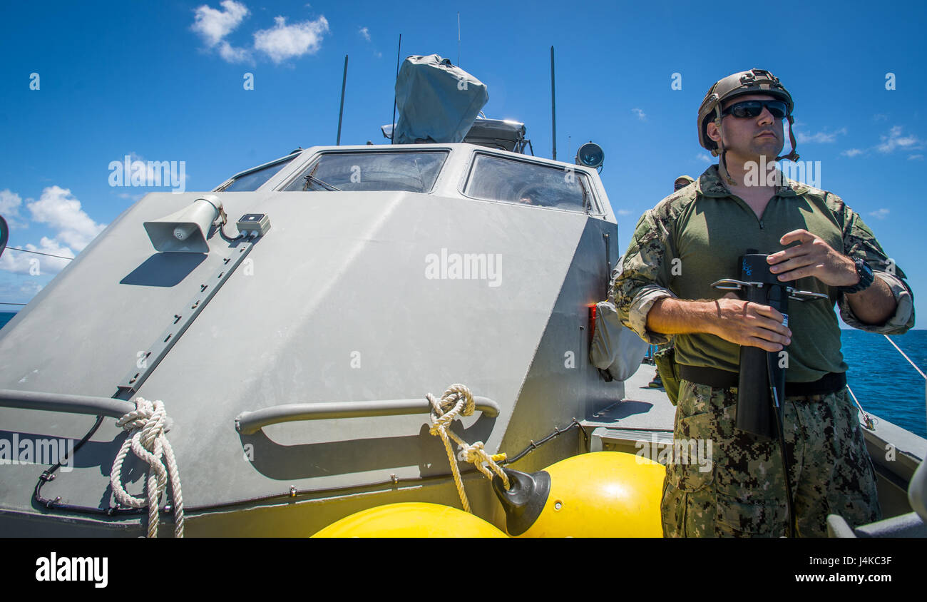 Un marin affecté à l'unité mobile de destruction des engins explosifs (5) 142 EODMU5 Peloton utilise un dispositif de signalisation acoustique à bord d'une rivière côtière 1 Groupe Guam Détachement MK VI le bateau de patrouille pour recevoir les mises à jour de statut d'un véhicule sous-marin sans pilote au large de Saipan 9 mai 2017. EODMU5 est actuellement en train de tester sa capacité à déployer des actifs de différentes plates-formes, y compris des hélicoptères et des bateaux de patrouille, d'augmenter son interopérabilité adaptative. EODMU5 mène la lutte contre les mines, engins explosifs improvisés, les opérations de sécurité rend les dangers d'explosion et désarme explosifs sous-marins tels que Banque D'Images