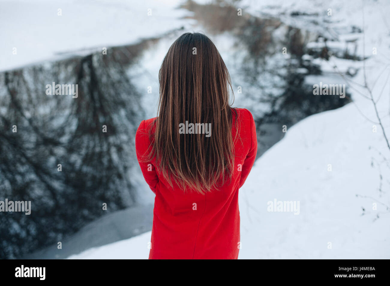 Vue arrière du Caucasian woman with long hair in snow Banque D'Images