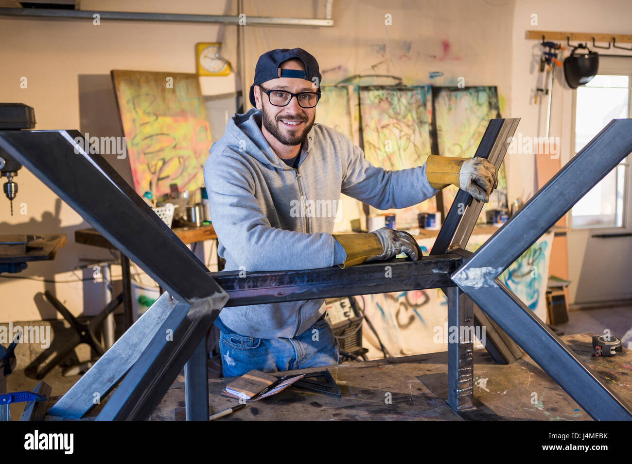 Portrait of young man leaning on metal sculpture Banque D'Images