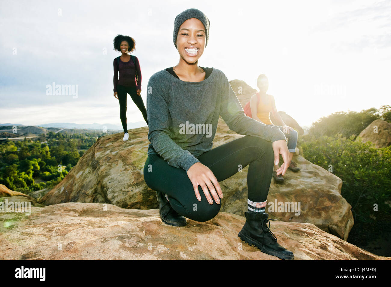 Portrait of smiling women posing on rock formation Banque D'Images