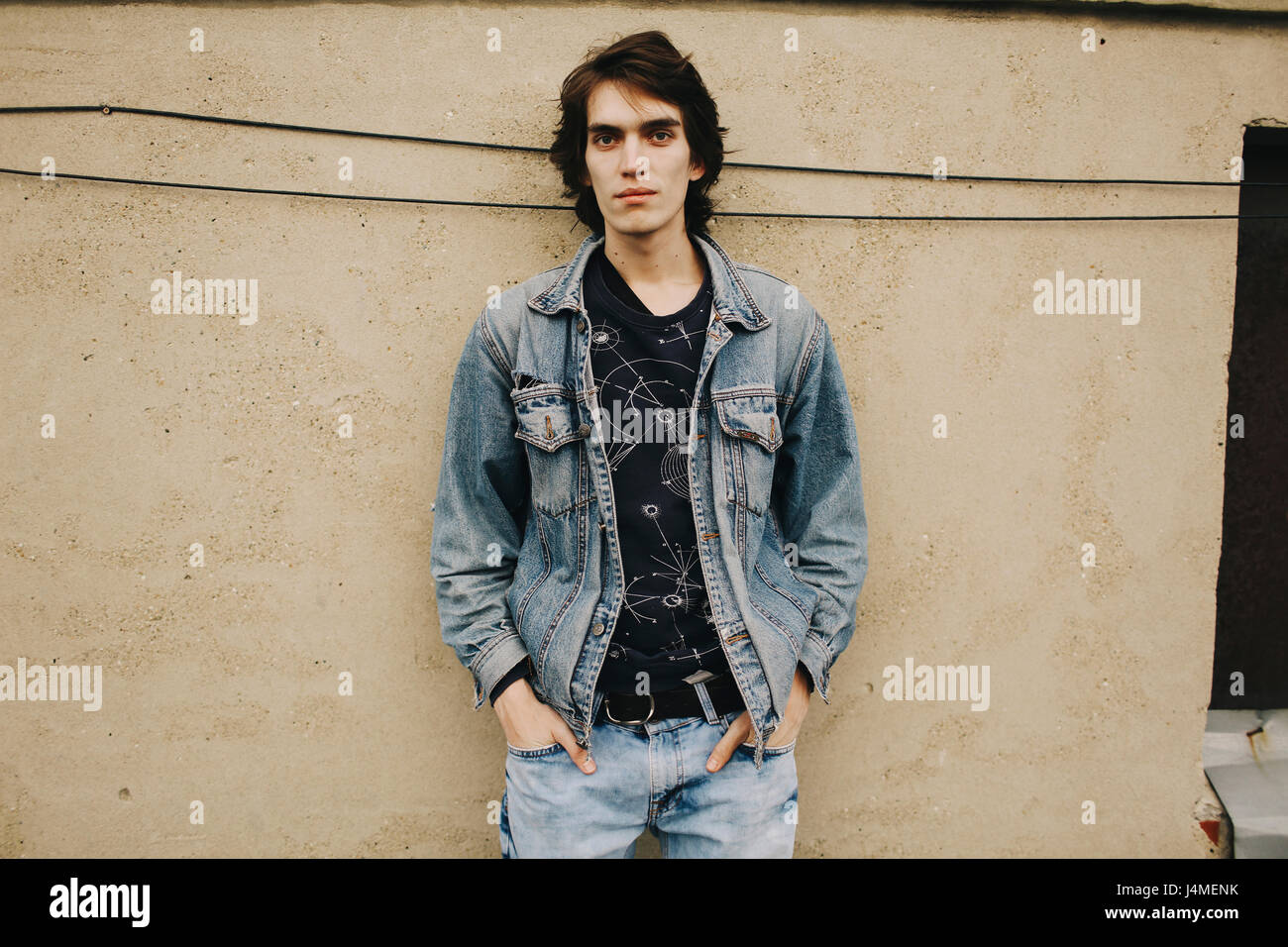 Portrait of young man leaning on wall Banque D'Images