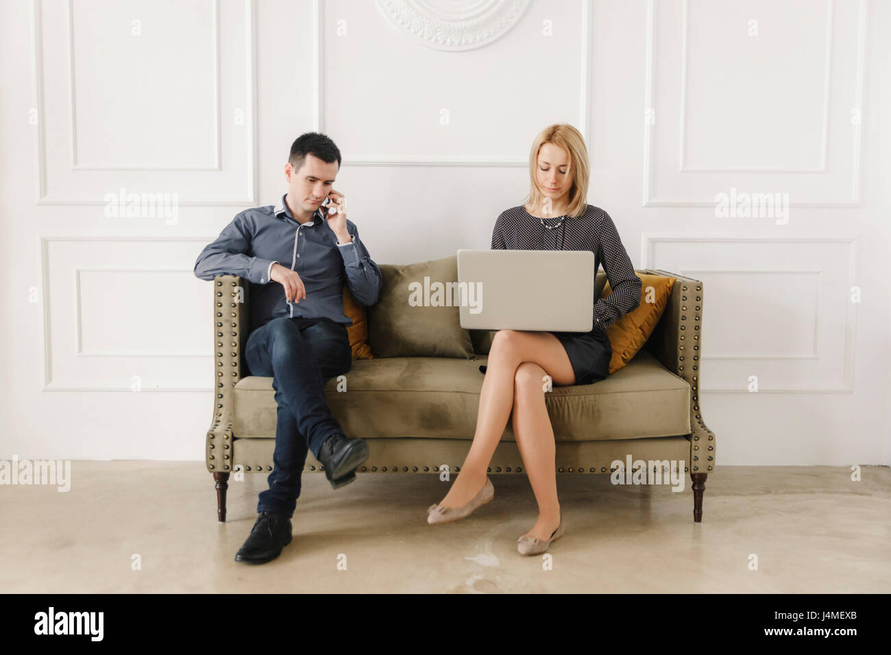 Middle Eastern woman sitting on sofa using technology Banque D'Images