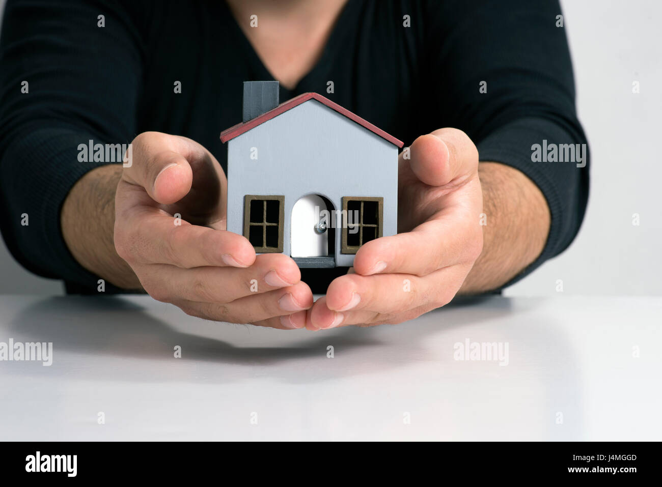 Maison modèle sur fond blanc et sur les deux mains. Banque D'Images