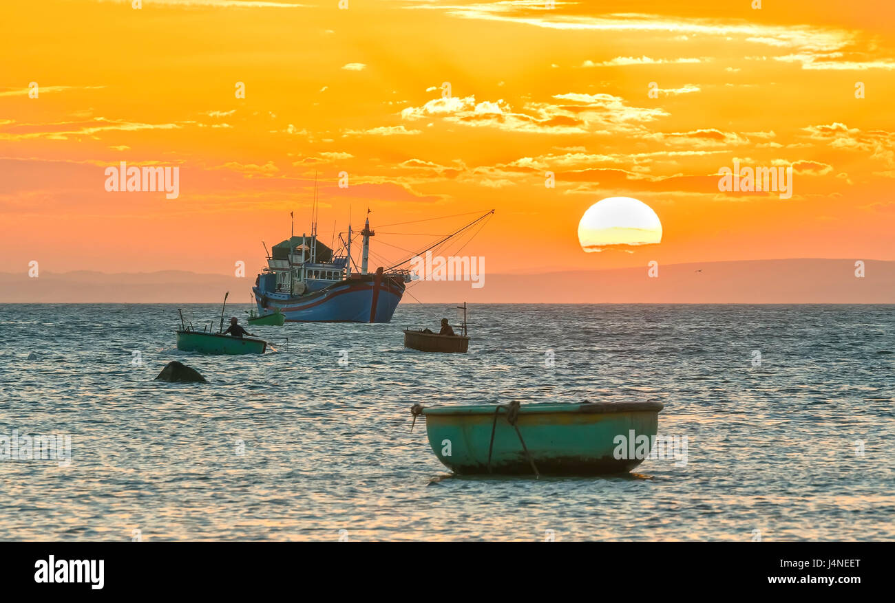 Le coucher et le bateau sur la mer que le soleil lentement sur l'horizon crée une belle lumière dorée sur la baie Banque D'Images