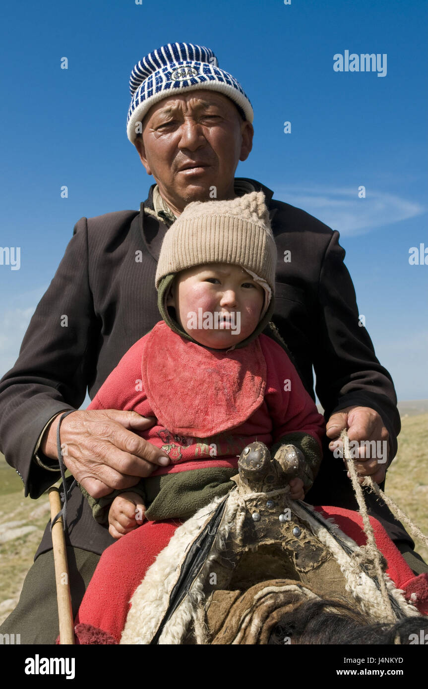 L'homme et son fils s'asseoir sur un cheval, chanson Köl, Kirghizistan, Banque D'Images