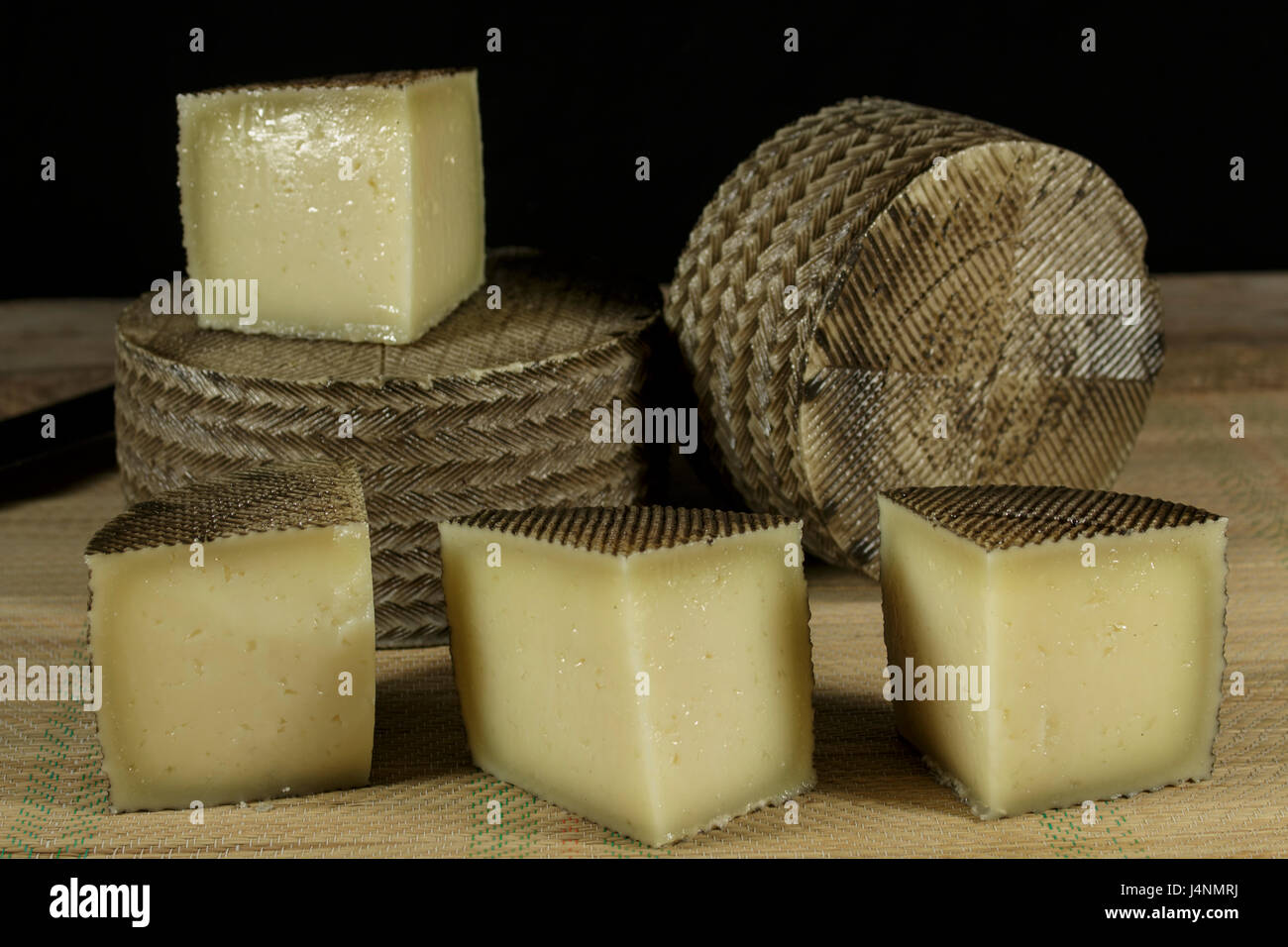 Plusieurs fromages Manchego, l'un d'entre eux coupé en morceaux Banque D'Images