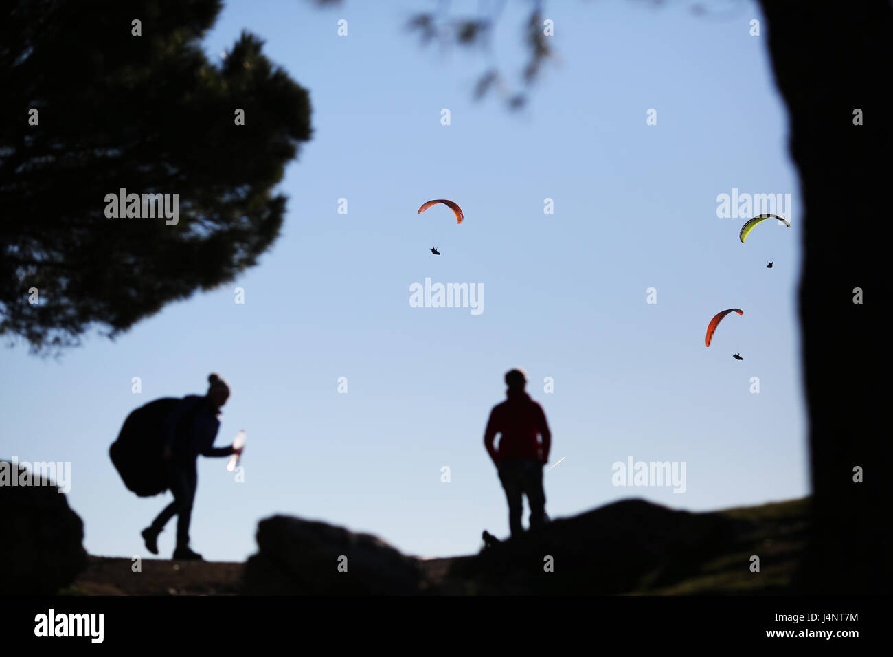 Deux pilotes regarder comme un groupe de parapentes planent les collines près de Algodonales, Espagne Banque D'Images