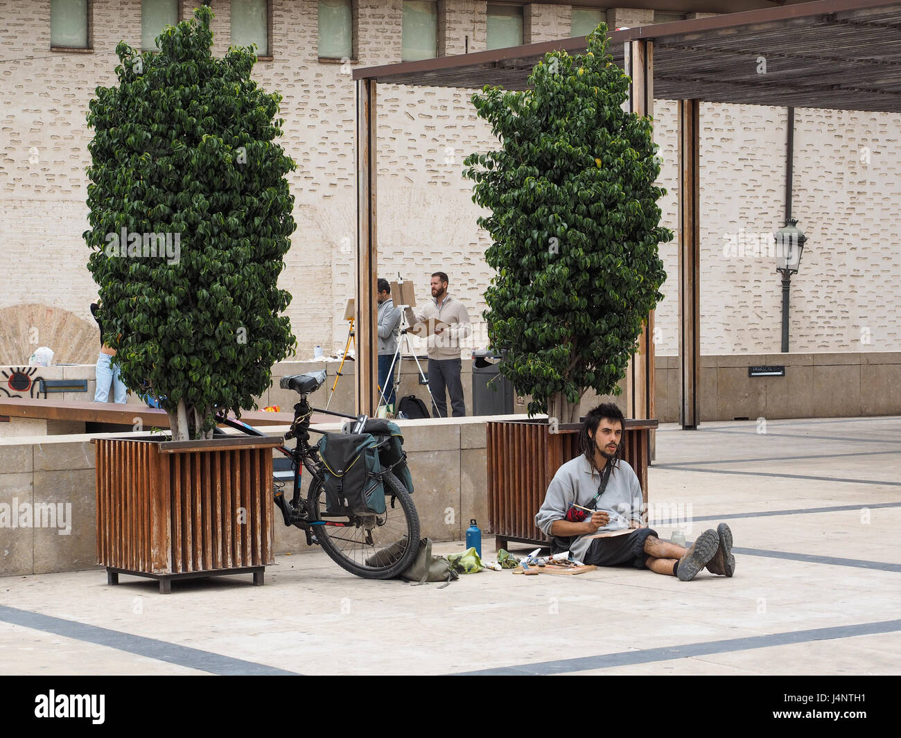 Artiste artistes travaillant dessin peinture en plein air assis sur marbre  sol debout à un un chevalet location vélo calé à Valence, Espagne Photo  Stock - Alamy