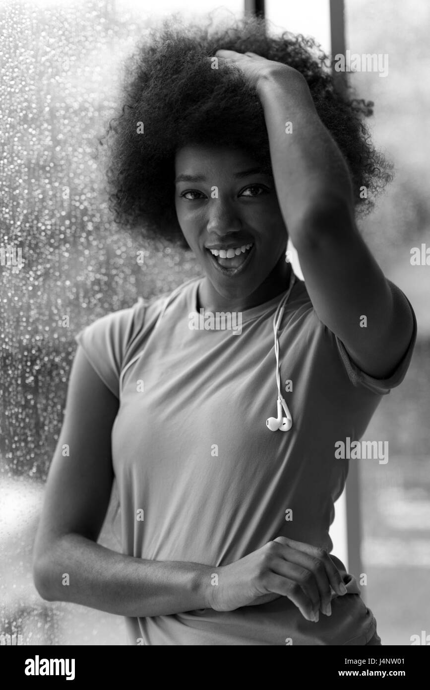 Portrait de femme jeune dans la salle de sport sur workout pause pendant l'écoute de la musique sur l'écouteur et le dancing jour de pluie et de mauvais temps outdooor Banque D'Images