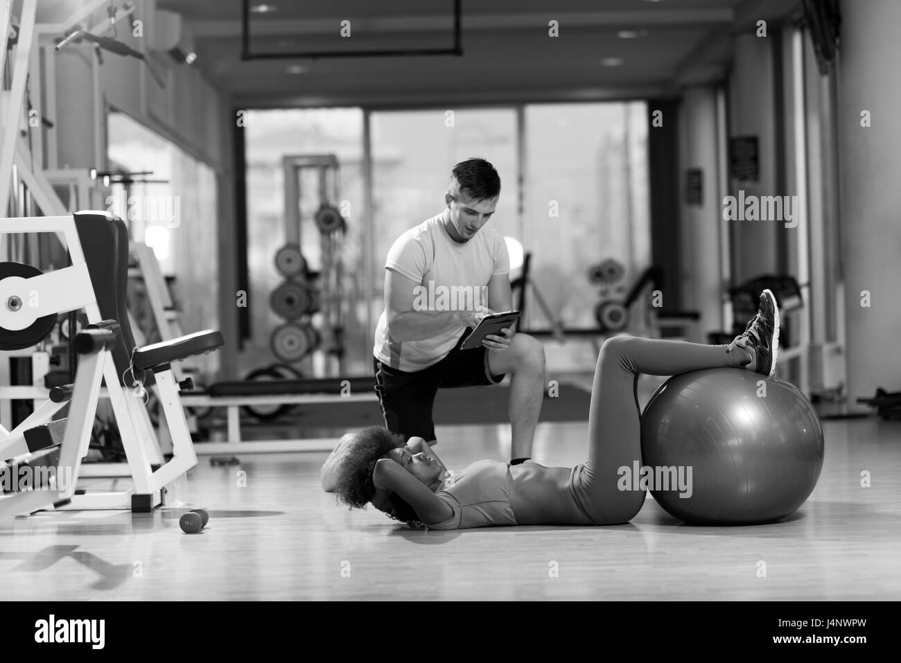 Jeune couple en bonne santé dans l'exercice d'entraînement pilates salle de sport avec un entraîneur personnel Banque D'Images