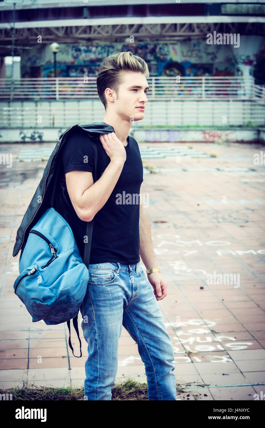 Jeune homme debout dans l'environnement de la ville, avec backsack Banque D'Images