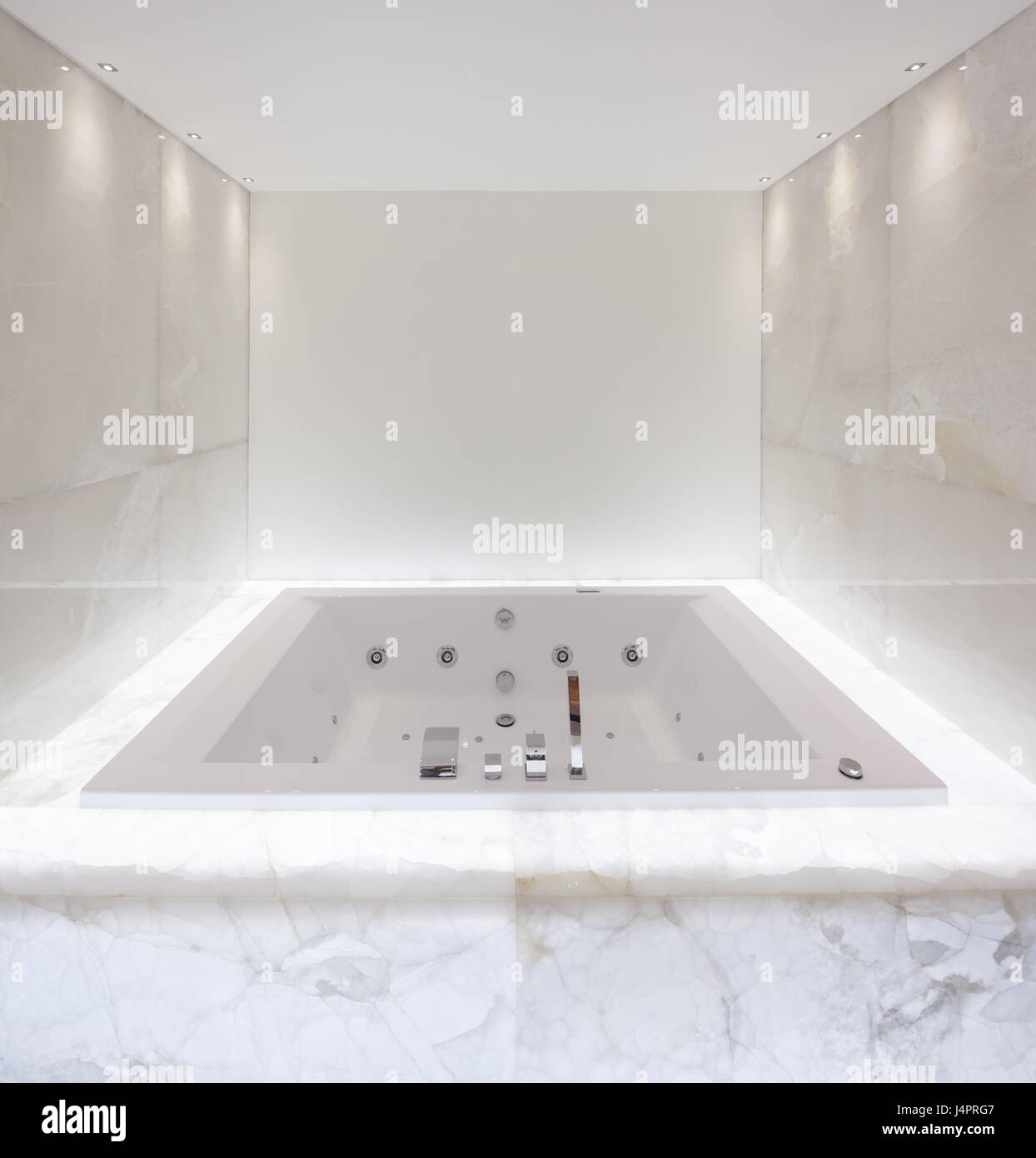 Grande baignoire à remous dans la salle de bain éclairée en Banque D'Images