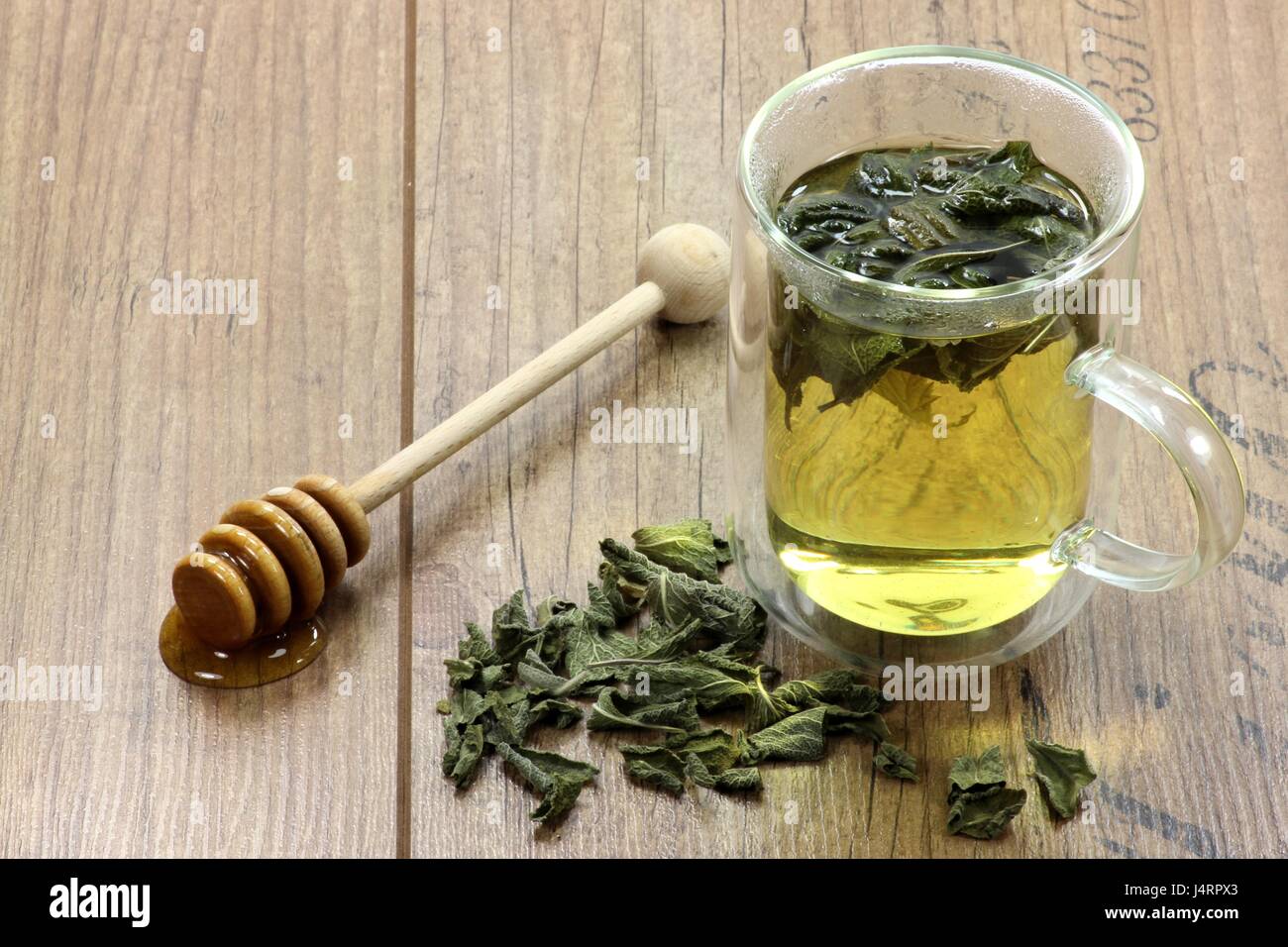 Sage du thé dans une tasse en verre double paroi sur fond de bois Banque D'Images
