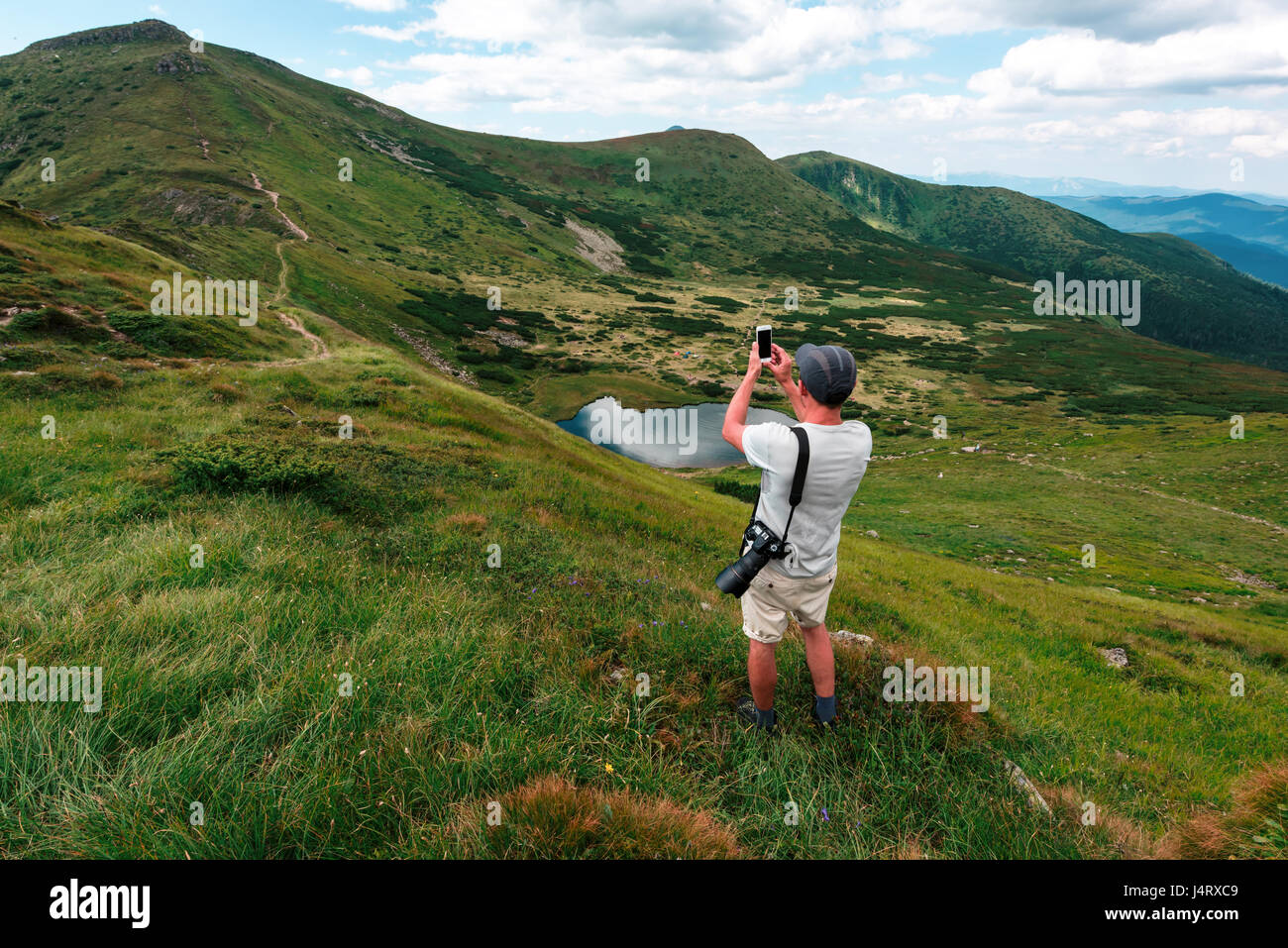 Une famille d'un séjour touristique sur le bord de la colline dans le contexte d'un incroyable paysage de montagne. Journée ensoleillée et ciel bleu Banque D'Images
