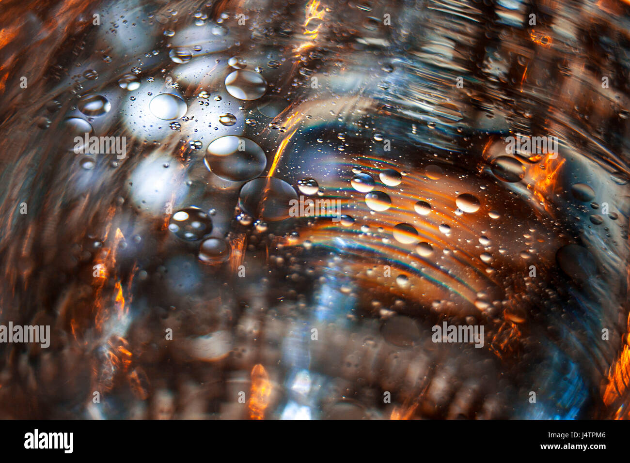 Une image explorer la combinaison de l'eau et les gouttelettes d'huile et de leur interaction avec la lumière colorée. Banque D'Images