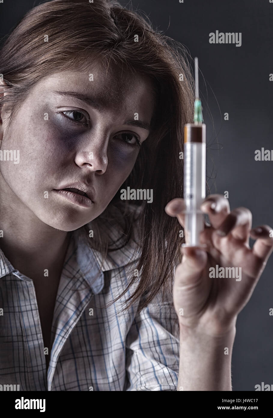 Jeune femme avec la toxicomanie sur fond sombre Banque D'Images