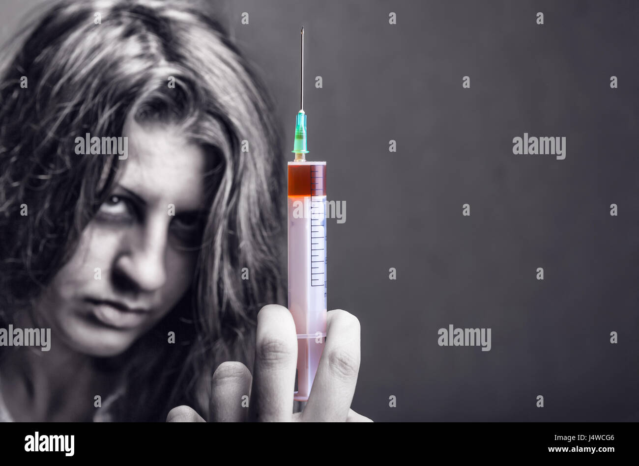 Femme avec la toxicomanie sur the backgroundю se concentrer sur seringue Banque D'Images