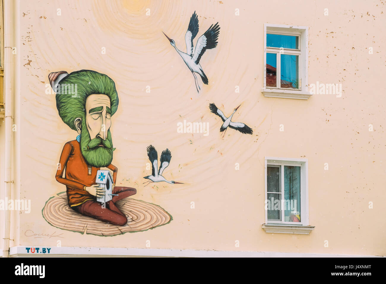 Gomel, Bélarus - Avril 9, 2017 : des graffitis dans la rue Krasnoarmeyskaya. Vieil homme met gratuitement à cigognes oiseaux de volière. Banque D'Images