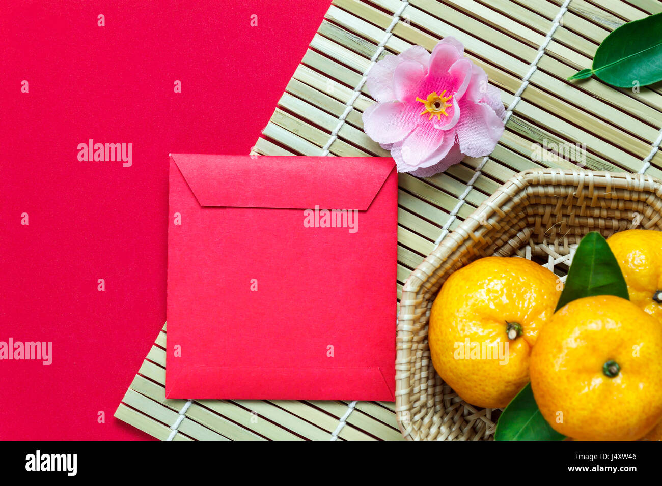 Haut afficher les accessoires le festival du Nouvel an chinois.décorations,orange,feuilles,panier Bois de prunier,paquet rouge sur fond rouge. Banque D'Images