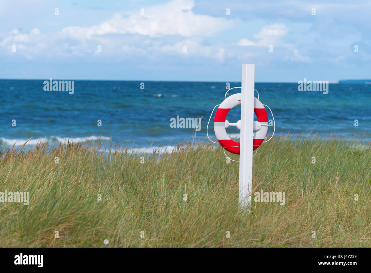 Orange avec bouée blanche le long d'une plage danoise Banque D'Images