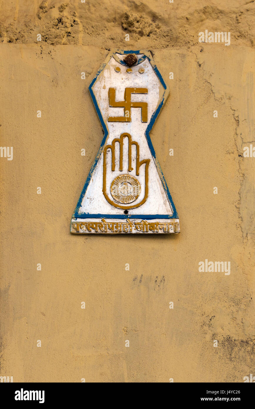 Le symbole officiel du jaïnisme, connu sous le nom de Jain Prateek Chihna, affichée sur le mur extérieur peints en jaune. Banque D'Images
