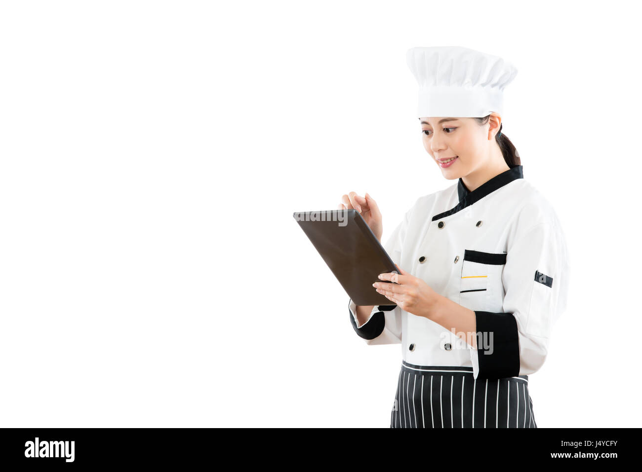 Smiling asian woman using digital tablet chef pour vérifier menu commande de nourriture. isolé sur fond blanc. profession et l'industrie job concept. Banque D'Images Smiling asian woman using digital tablet chef pour vérifier menu commande de nourriture. isolé sur fond blanc. profession et l'industrie job concept. Banque D'Images