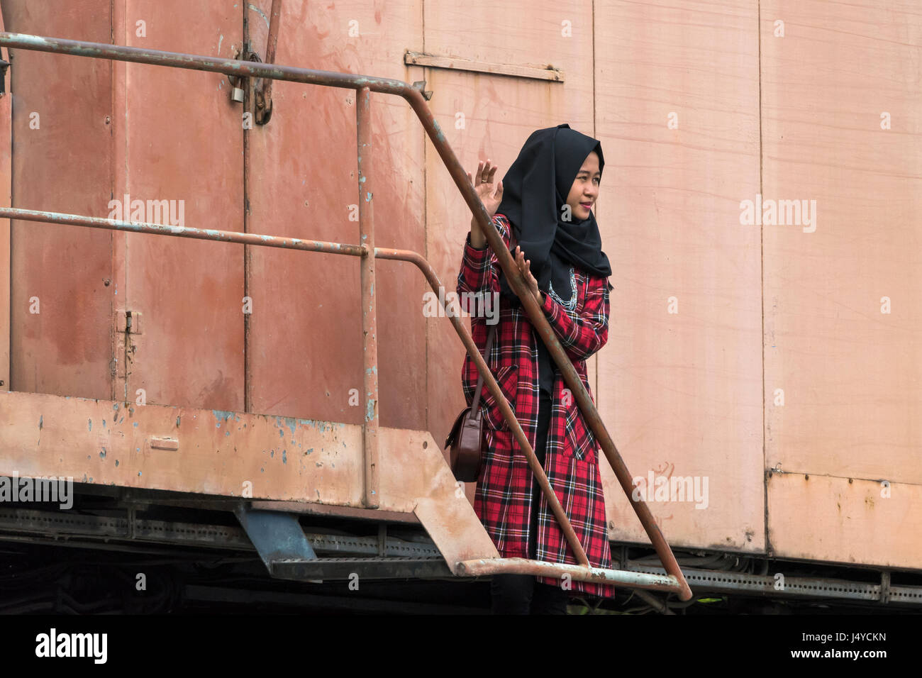 Femme dans une robe à carreaux noirs et hijab, Port de Sunda Kelapa, Jakarta, Indonésie Banque D'Images