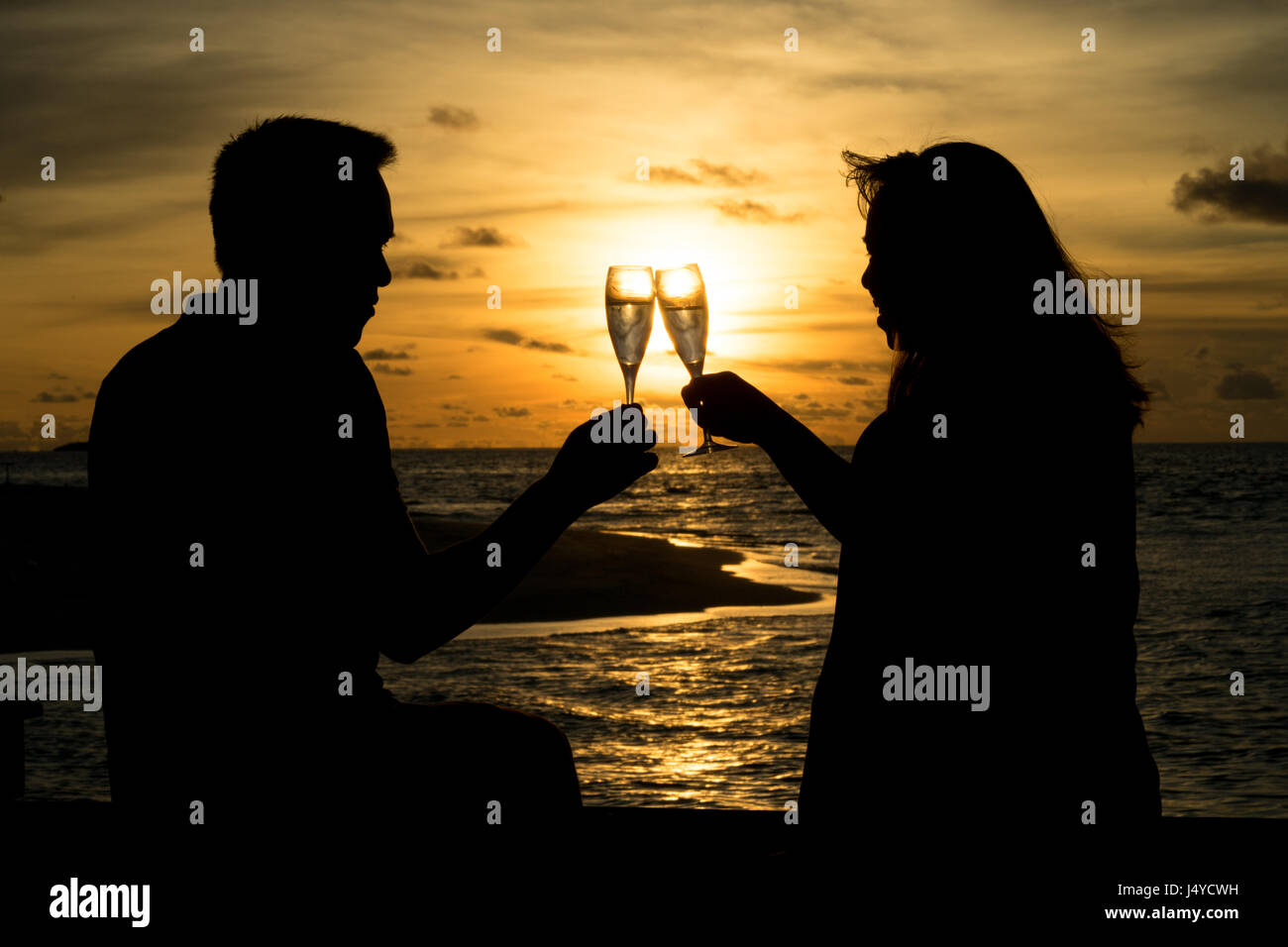 Couple buvant un verre de vin dans un cadre de vacances tropicales Banque D'Images