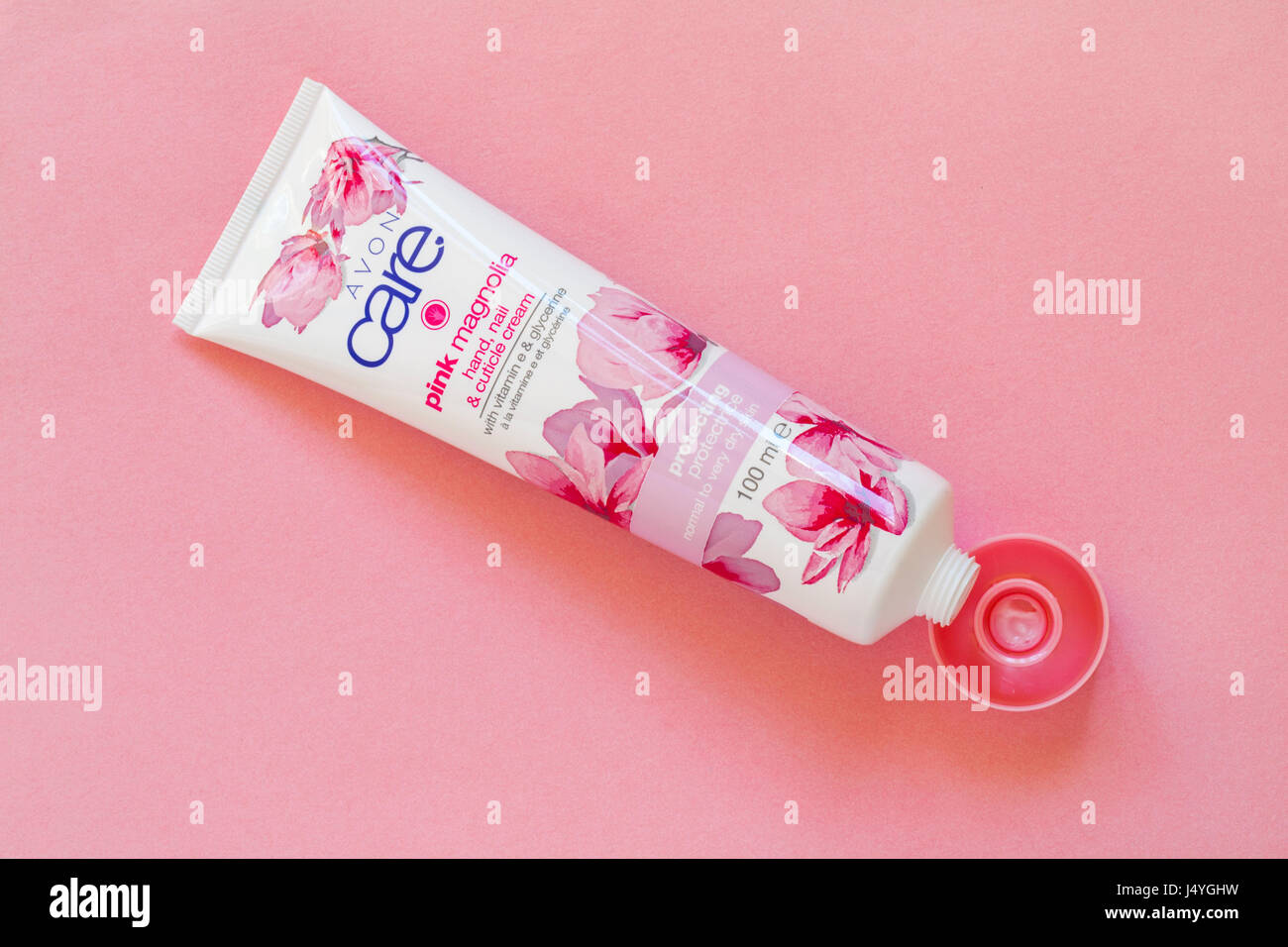 Avon care magnolia rose, la main & ongles crème de cuticle avec vitamine e et la glycérine protéger normal de peau très sèche - 100ml tube isolé sur fond rose Banque D'Images