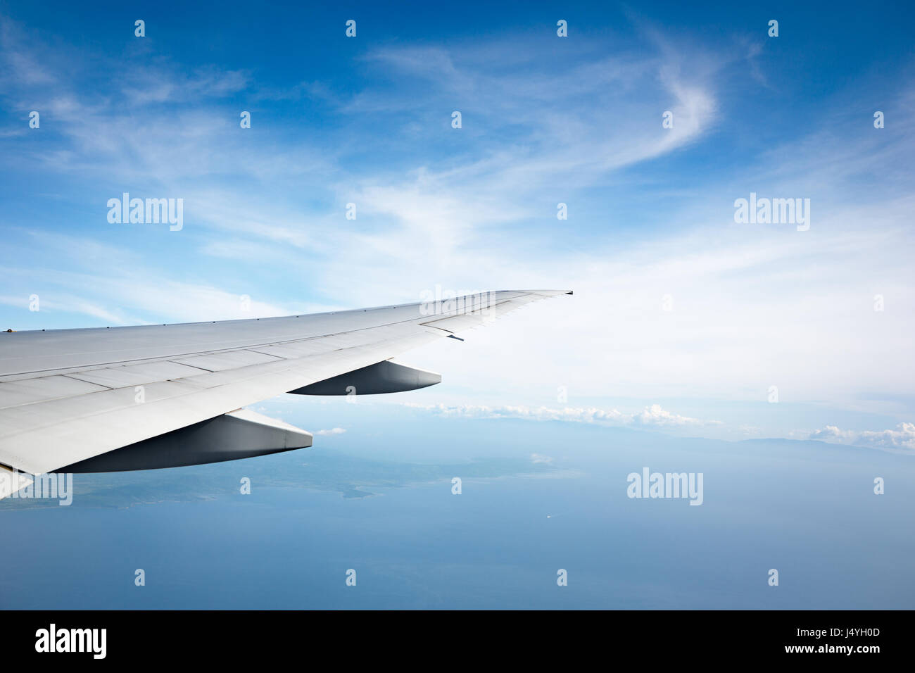 Océan et aile d'avion vue depuis la fenêtre de l'avion Banque D'Images