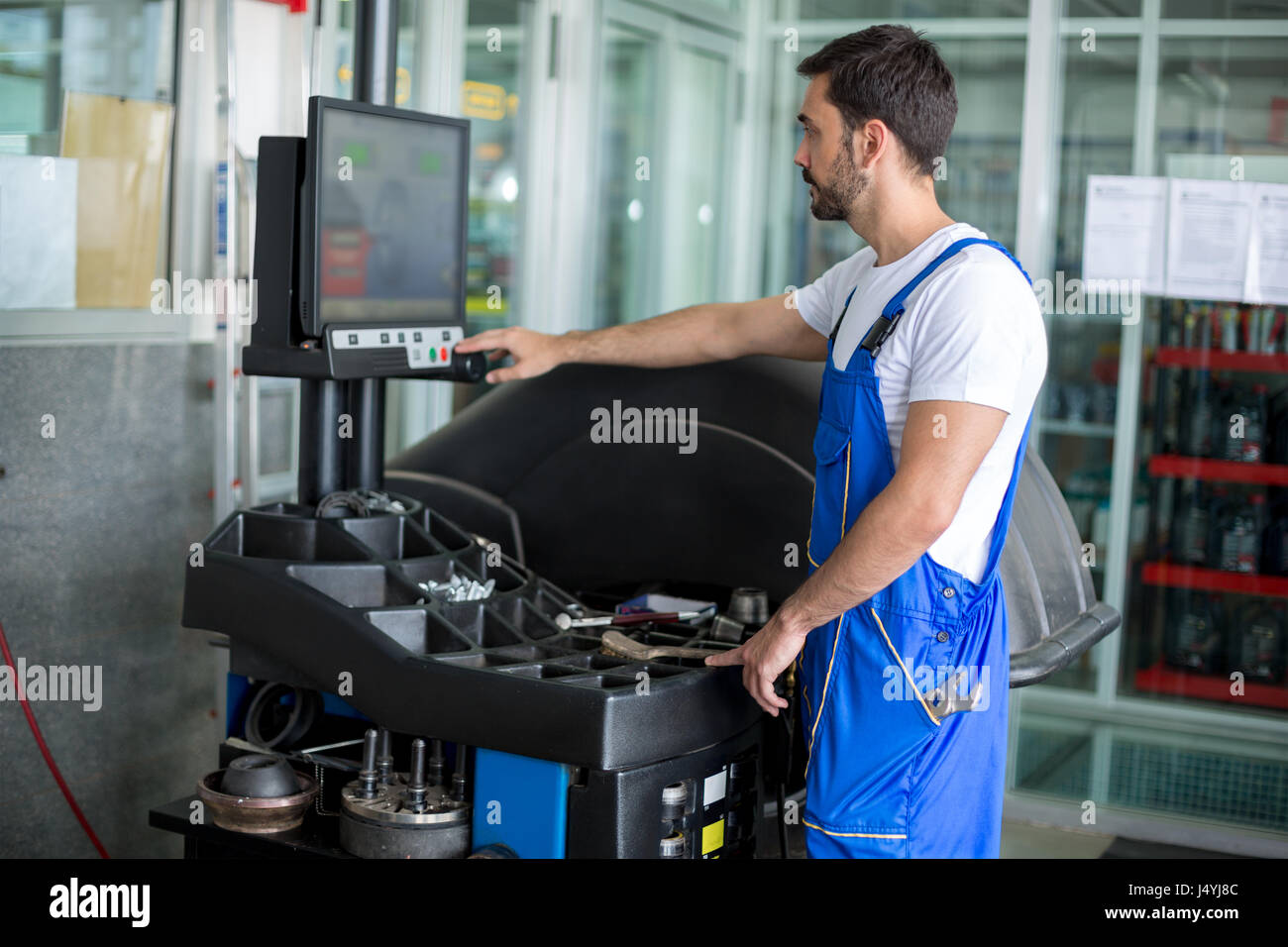 Mécanicien de machine à équilibrer au garage Banque D'Images