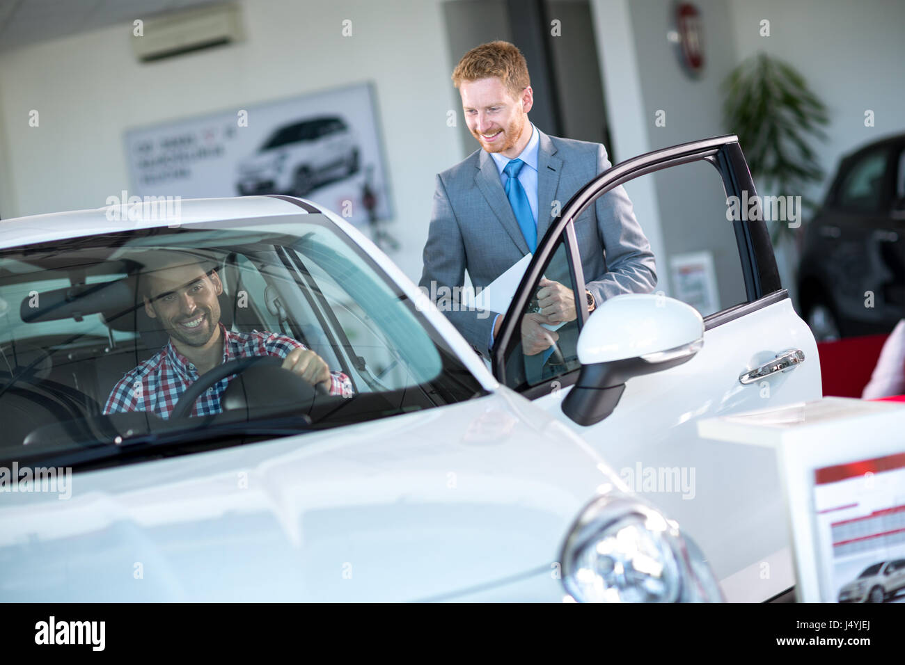 Friendly votre montrant nouvelle voiture à la clientèle masculine Banque D'Images