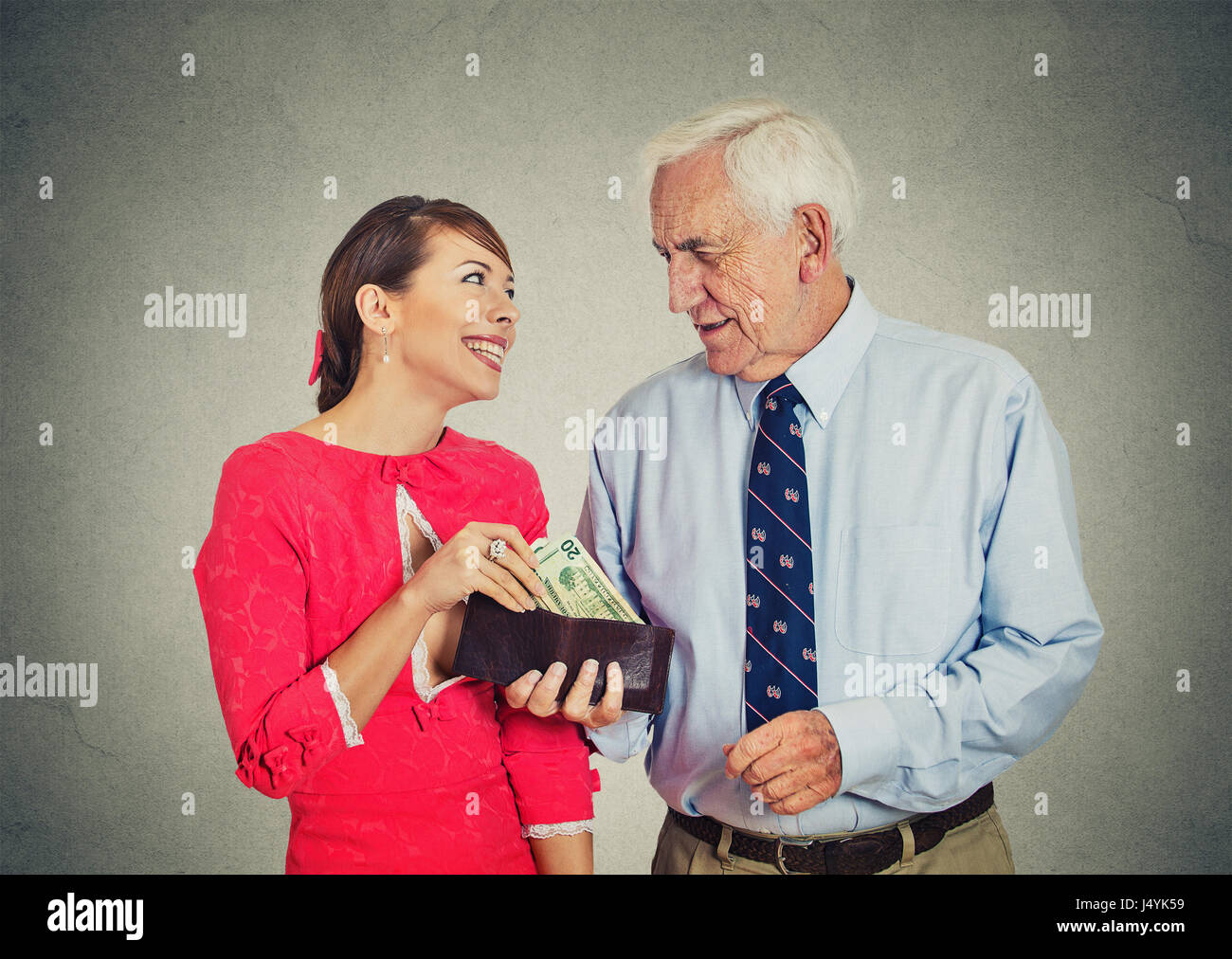 Personnes âgées Senior businessman patron et son magnifique jeune maîtresse isolé sur fond de mur gris Banque D'Images