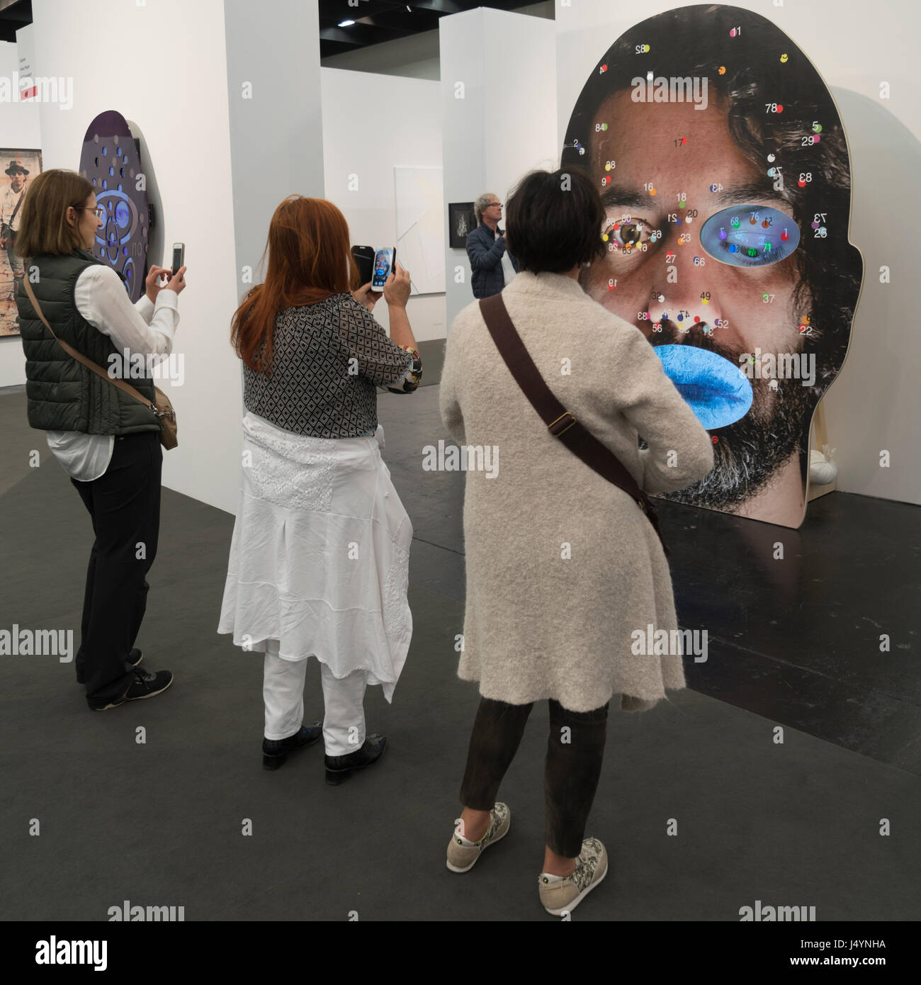 Les gens observent les installations vidéo de Tony Oursler à ART Cologne. Banque D'Images