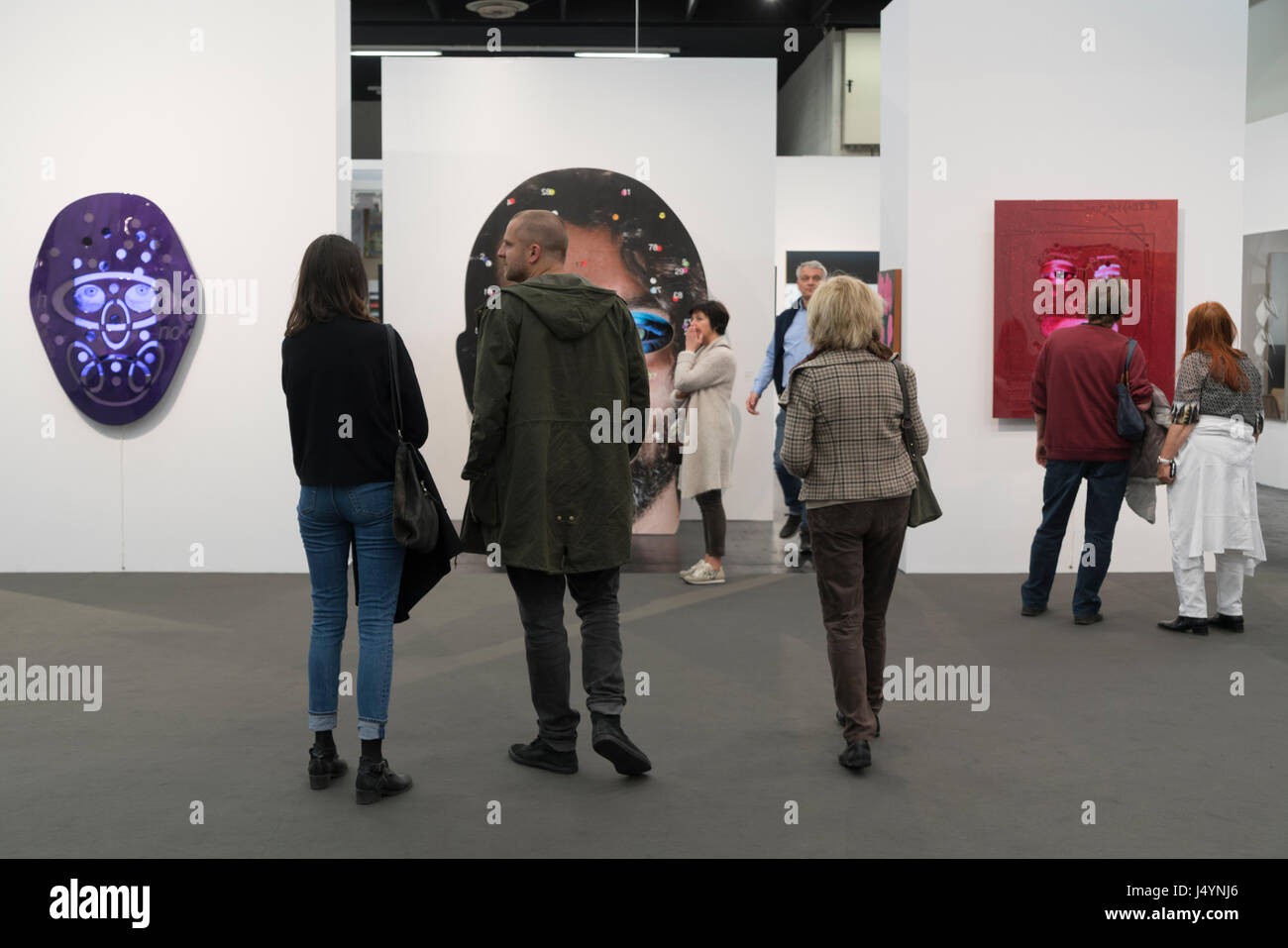 Les gens observent les installations vidéo de Tony Oursler à ART Cologne. Banque D'Images