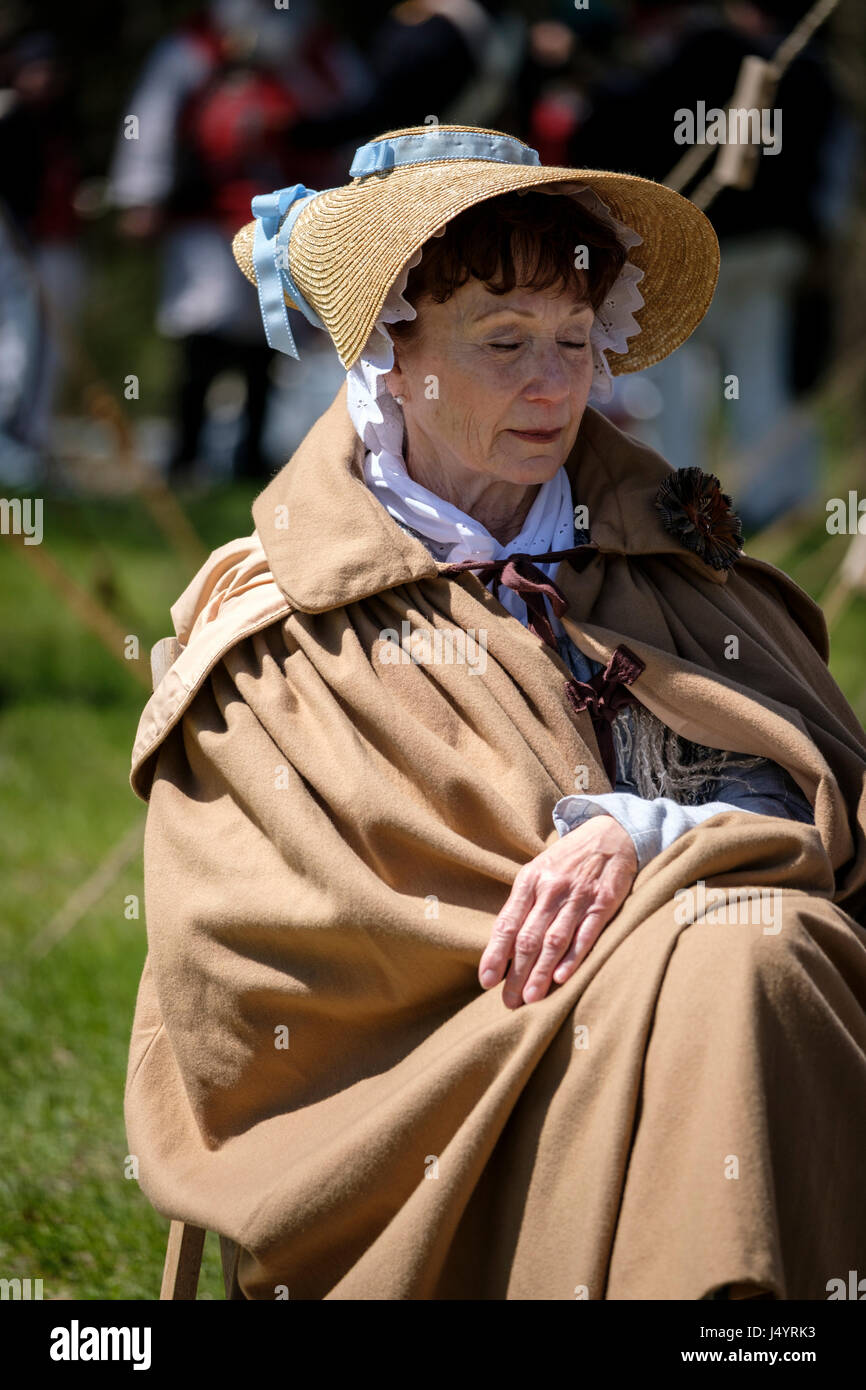 Bataille de Longwoods de reconstitution 1812, femme d'âge moyen portant un chapeau de paille avec ruban bleu, et un pelage brun, le sommeil, le repos, l'Ontario, Canada. Banque D'Images