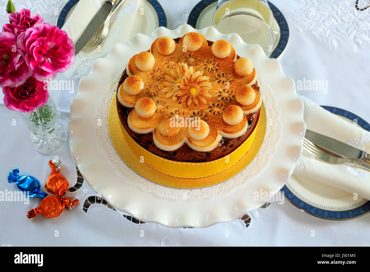 Simnel cake - gâteau aux fruits traditionnel de Pâques décorés de massepain sur un set de table pour le thé. Banque D'Images