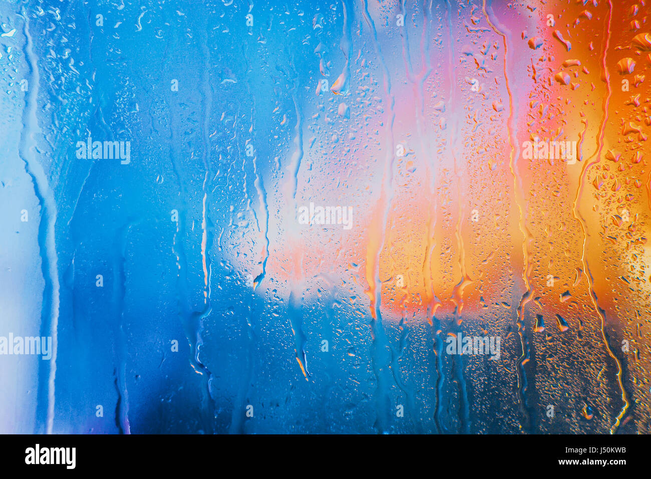 Gouttes de pluie sur un fond multicolore brouillée. Banque D'Images