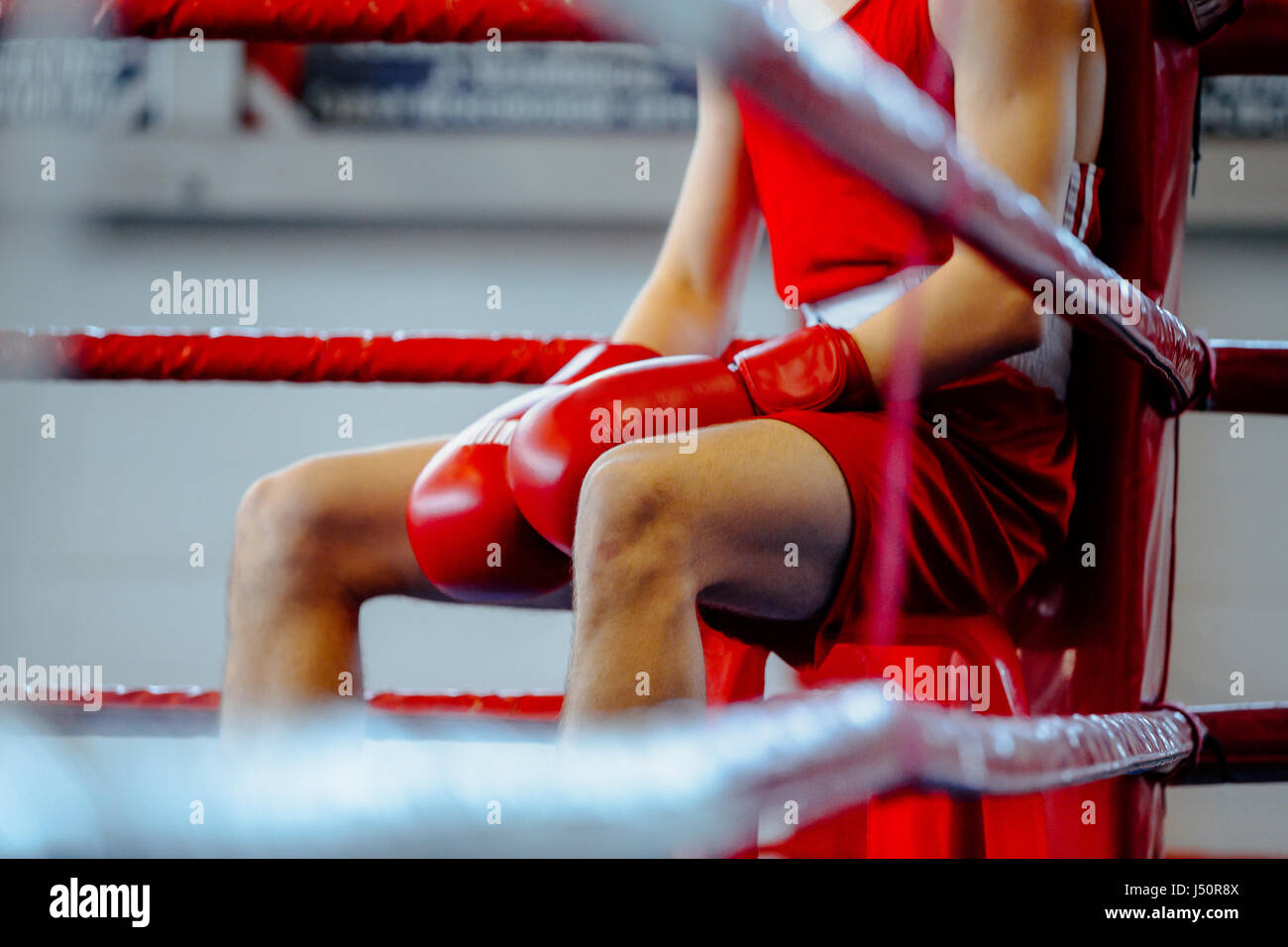 Jeune homme boxer en corner ring de boxe en pause entre les tours Banque D'Images