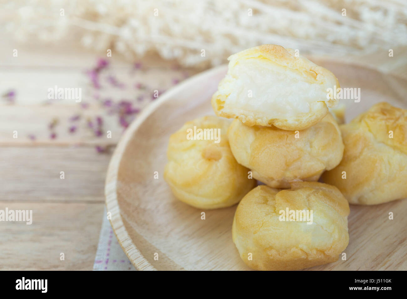 Éclairs à la crème de vanille sur table en bois Banque D'Images