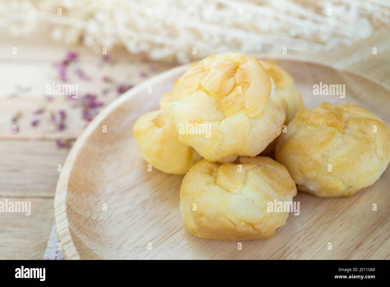 Éclairs à la crème de vanille sur table en bois Banque D'Images