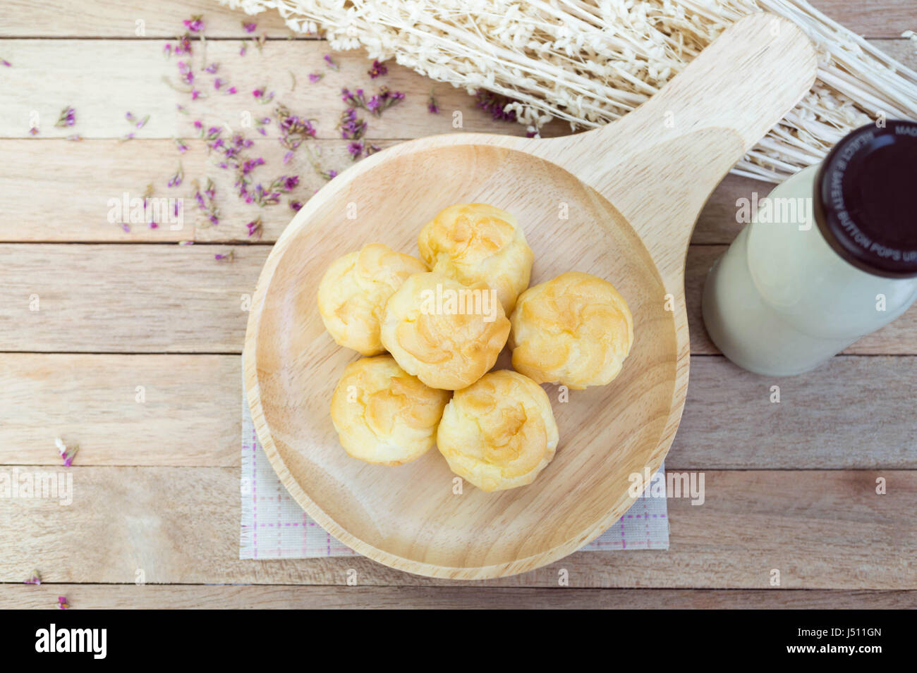 Éclairs à la crème de vanille sur table en bois Banque D'Images
