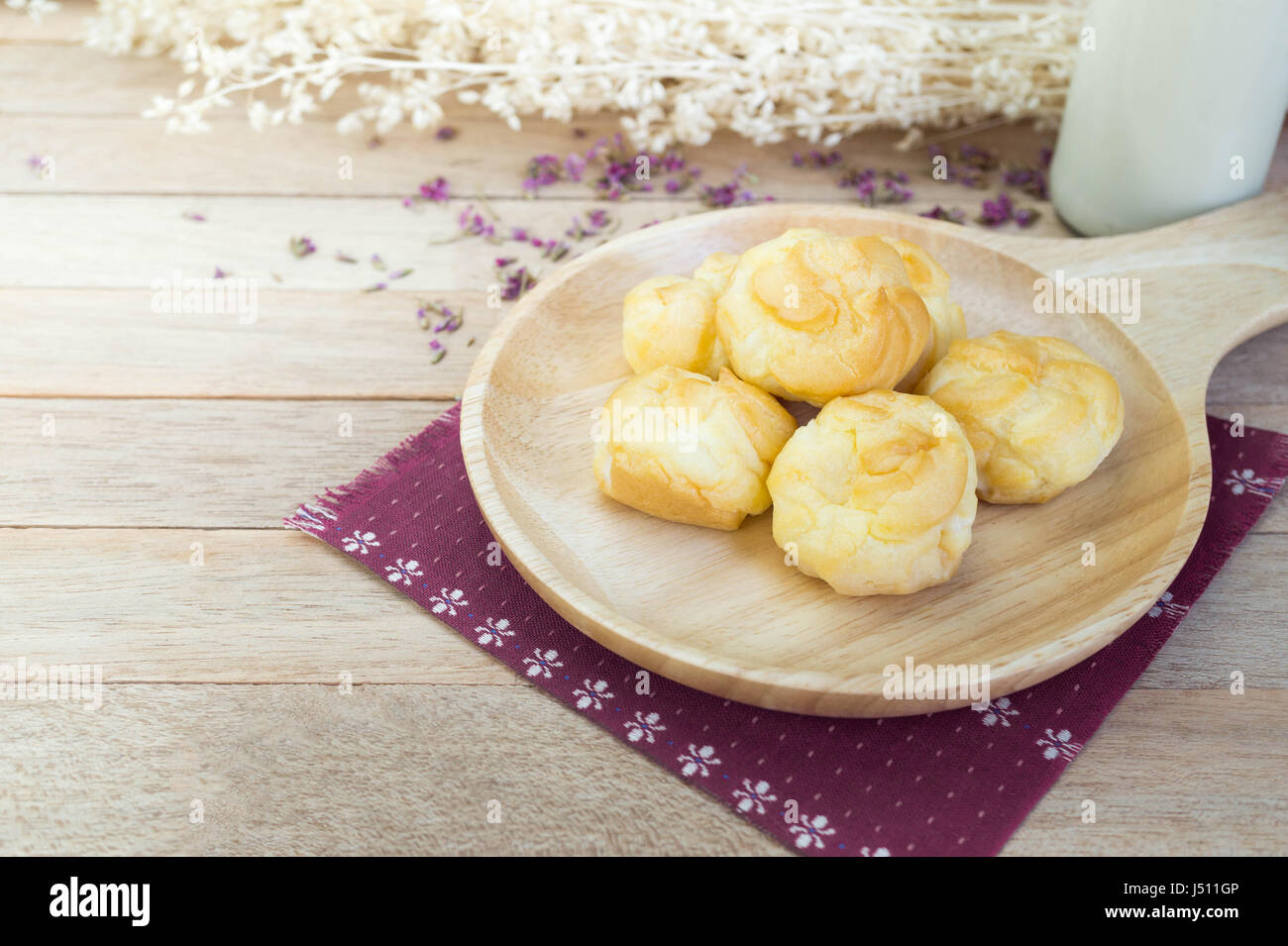 Éclairs à la crème de vanille sur table en bois Banque D'Images